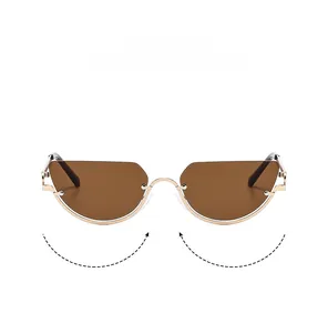 Close-up of golden metal cat-eye sunglasses featuring nose pads and half-frame structure