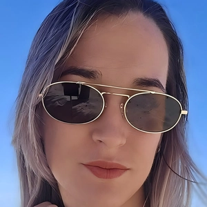 Vintage oval double bridge metal sunglasses with gold frame and dark lenses on model