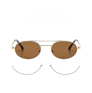 Detail of vintage oval gold metal double bridge sunglasses with dark brown lenses