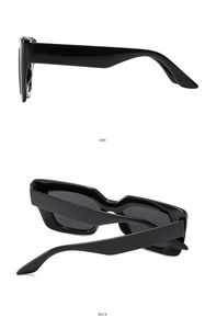 Detail view of wide temples and geometric lines on black square frame sunglasses