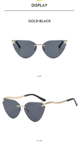Detailansicht der gold-schwarzen randlosen Cat-Eye-Sonnenbrille mit strukturierten Bügeln