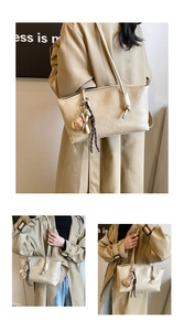 Detail of beige textured leather tote with knotted handle and plush charm accessory