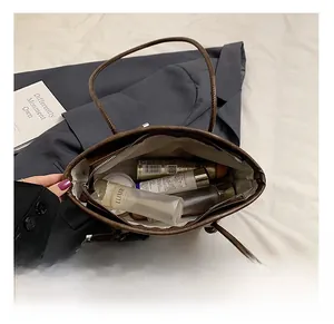 Detailed interior of the brown leather tote bag showing large capacity and zipper pocket