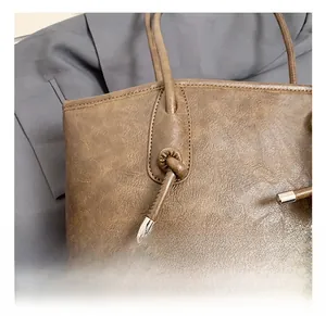 Detail of silver hardware and premium brown leather texture on a large tote bag