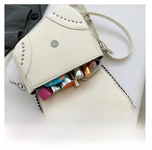 Détail de l'intérieur du sac selle crème avec rivets montrant sa capacité de rangement