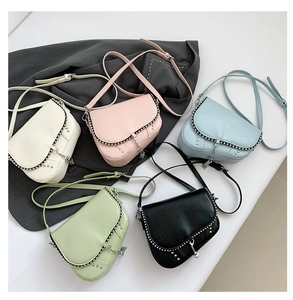 Vue détaillée des sacs de selle avec bords à rivets et pompons en cinq coloris variés