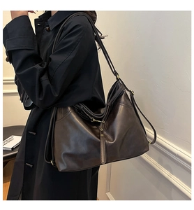 Detailed close-up of dark brown vintage leather tote bag with stylish strap buckle detail