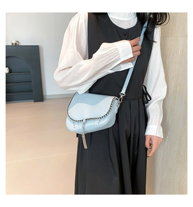 Détail du sac besace bleu clair avec rivets métalliques et pampilles à franges argentées