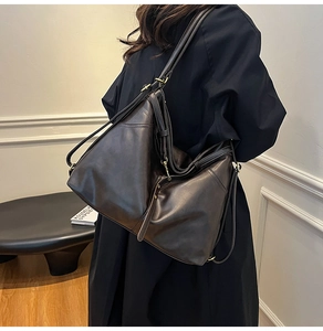 Detail der dunkelbraunen Leder-Shopper-Tasche mit dekorativen Riemen in Lifestyle-Szene