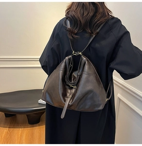 Detail of vintage brown leather tote bag showing backpack strap style and soft texture
