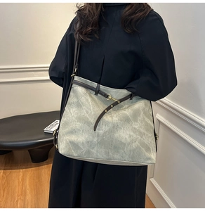 Detailansicht der großen Shopper-Tasche aus grau-grünem Leder mit braunen Kontrastriemen