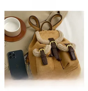 Detail view of winter plush backpack with brown suede texture and faux shearling trim