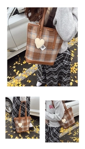 Détail du sac cabas en laine à carreaux marrons avec breloque en peluche cœur blanc