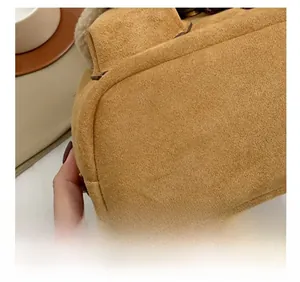 Detail view of precise stitching and soft sherpa trim on the brown suede winter backpack