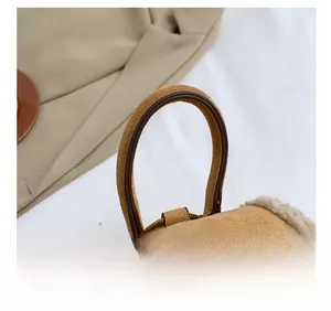 Close-up of brown suede backpack with cream faux fur trim and curved handle detail