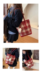 Détail du sac cabas à carreaux rouge et crème avec charm cœur en peluche et bandoulière rouge