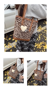 Vue détaillée d'un sac cabas zébré avec anses en cuir marron et pendentif cœur en peluche