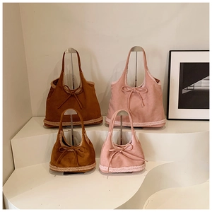 Close-up of brown and pink suede tote bags with lamb wool trim and bow detail