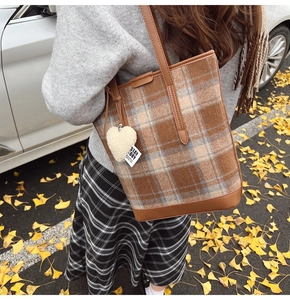 Détail du sac cabas en laine avec motif à carreaux vintage et breloque coeur