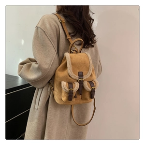 Detail view of ginger suede backpack featuring white faux shearling trim and leather straps