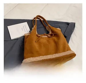 Detail of caramel suede tote bag with faux shearling trim and decorative bow accent