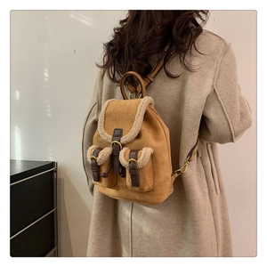 Detail of camel plush backpack with faux shearling trim and vintage leather buckles