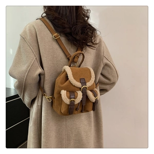 Close-up of a vintage brown suede backpack with white faux fur trim on a model's back