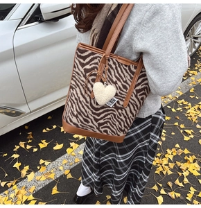 Détail du grand sac cabas à imprimé zèbre avec finitions marron et charm cœur