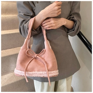 Pink faux suede handbag with plush cream sheepskin trim and a decorative bow tie accent
