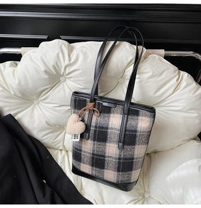 Détail du sac cabas en tweed à carreaux avec lanières en cuir et pendentif cœur en peluche