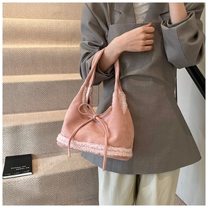 Detail of pink faux suede tote with plush lamb wool trim and bow detail for winter
