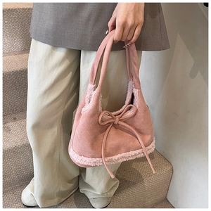 Detail of pink faux suede tote with white shearling trim and bow tie decoration