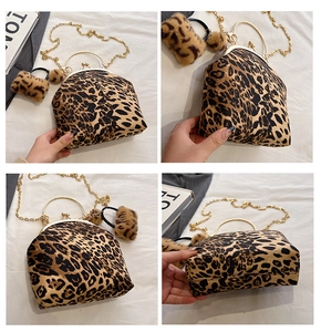 Detail view of leopard print shell bag with gold metal handle and chain strap