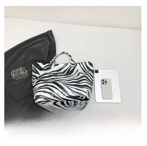 Detailed view of large zebra print PVC tote bag with black and white animal pattern texture