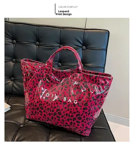 Detail of fuchsia leopard print tote bag with glossy finish and white TOTE BAG text