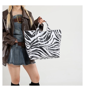 Detail of zebra print tote bag with glossy finish and durable wide top handle straps