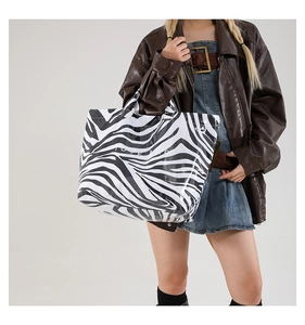 Zebra print large tote bag with white TOTE BAG text shown on model in studio