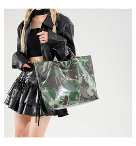 Detail of a camo print tote bag with white lettering worn by a model in a leather jacket