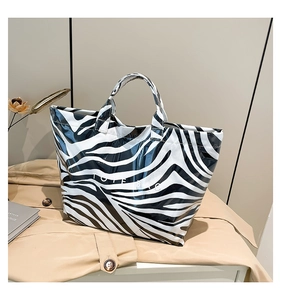 Detail of glossy zebra print tote bag with high-shine finish and Tote Bag lettering