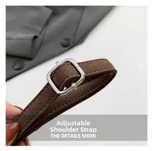 Close-up of brown suede shoulder strap with silver square adjustable buckle detail