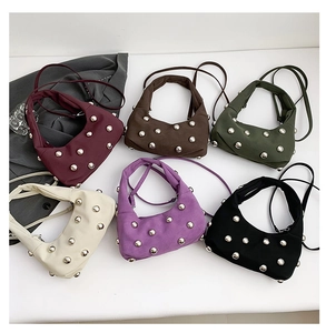 Flat lay of small canvas saddle bags with silver rivets in six different colors