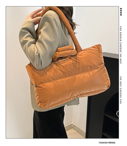 Macro shot of glossy caramel quilted tote bag featuring padded nylon texture and handles