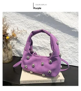 Detail of purple suede handbag with silver metal ball studs and dual carry straps