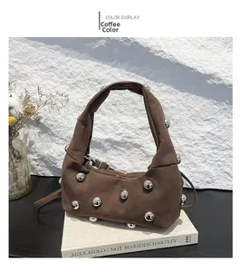 Detail view of coffee suede shoulder bag featuring silver spherical metallic studs and wide handle