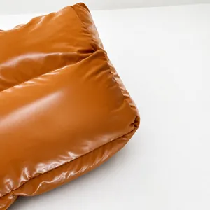 Detail of glossy quilted down fabric with glossy caramel brown finish and padded texture