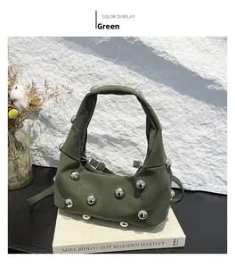 Detail of dark green hobo bag featuring spherical silver studs and sleek shoulder strap