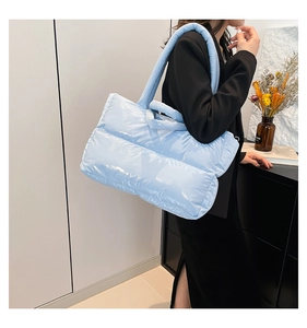 Close-up of light blue puffer tote bag with quilted padding and glossy nylon finish