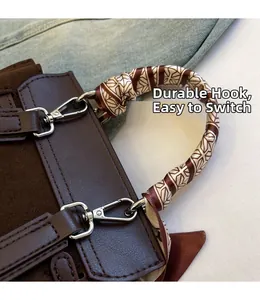 Detail of suede handbag featuring silk scarf wrapped handle and sturdy silver metal hooks
