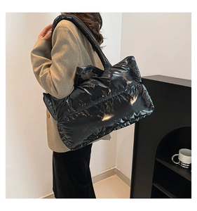 Side view of large black shiny padded tote bag showing waterproof high-gloss texture