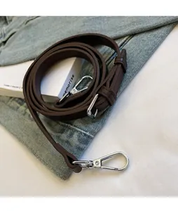 Detail of adjustable dark brown synthetic leather strap with silver metal swivel hooks